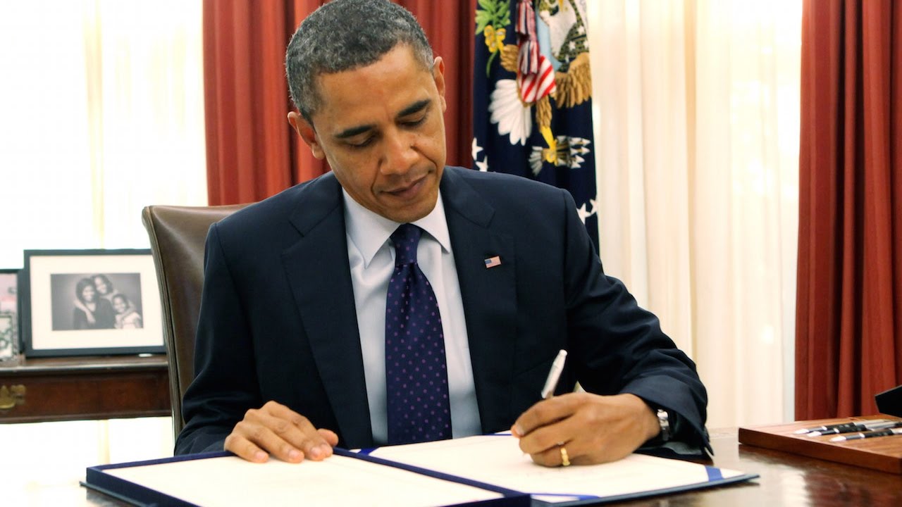 Image of President Barack Obama signing an executive order in the Oval Office