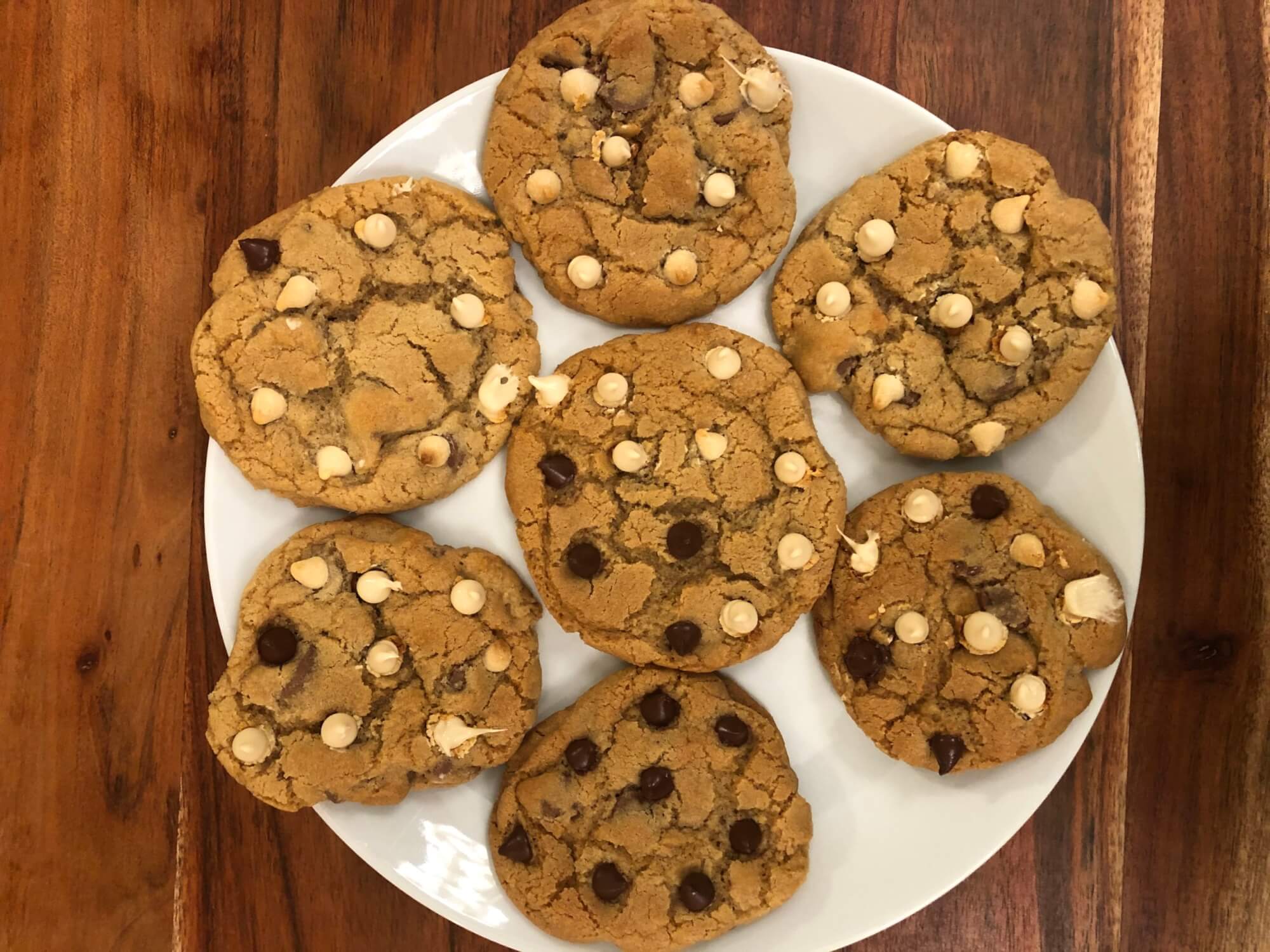 A plate of chocolate chip cookies white and dark chocolate chips; each cookie has variable numbers of white and dark chocolate chips
